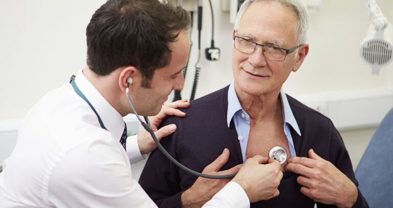 Doctor Listening To Man's Heart With A Stethoscope