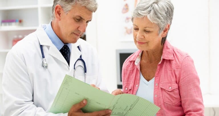 Woman Reviewing Papers With Her Doctor