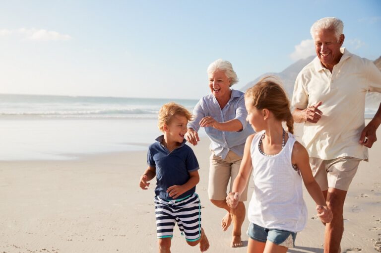 Grandparents And Grandchildren Jogging On The Beach