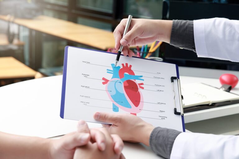 Doctor Explaining A Diagram Of A Heart To A Patient