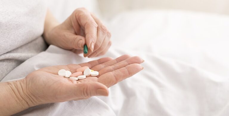 Woman Holding Several Kinds Of Pills In Her Hand