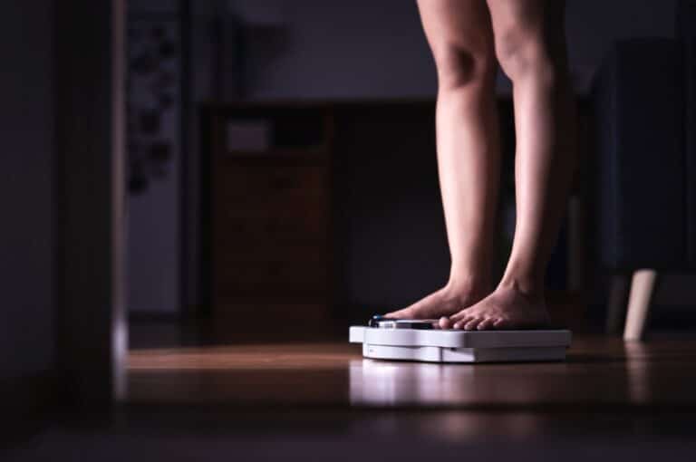 Woman Standing On A Bathroom Scale
